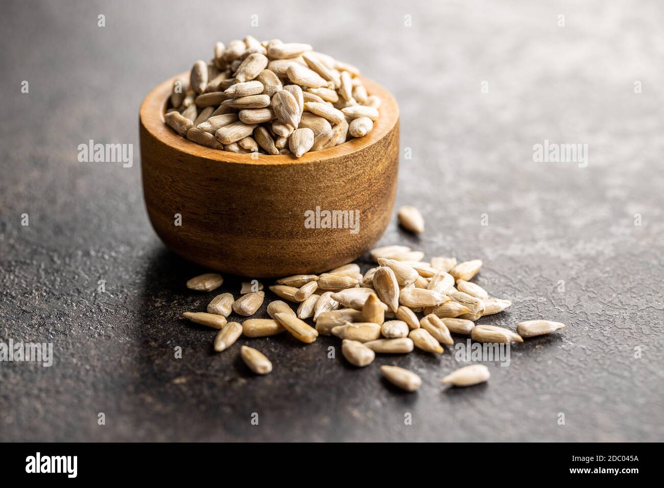 Peeled sunflower seeds in wooden bowl on black table Stock Photo - Alamy