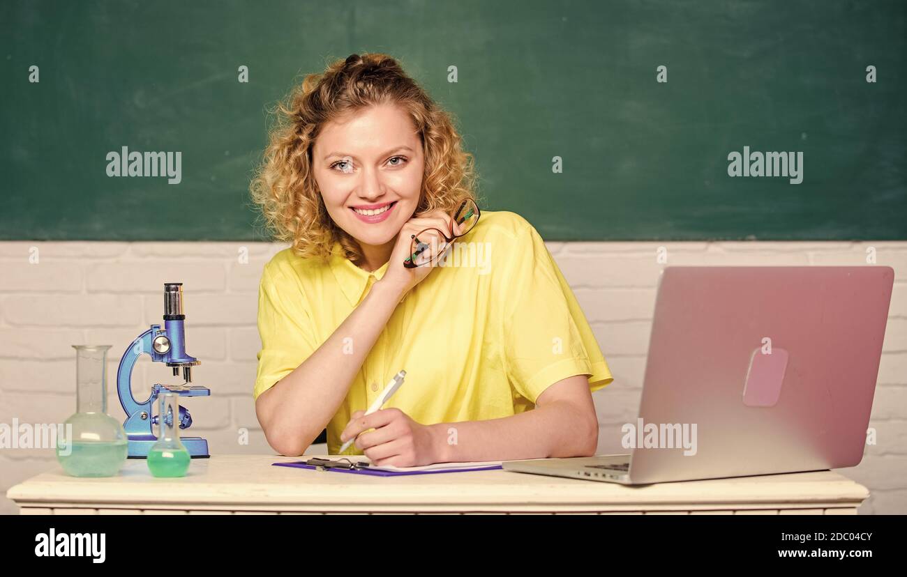 Chemical industry. girl in classroom laboratory. happy student with microscope and beaker. biology experiment research. make notes about chemistry research results. scientist at school lab. Stock Photo