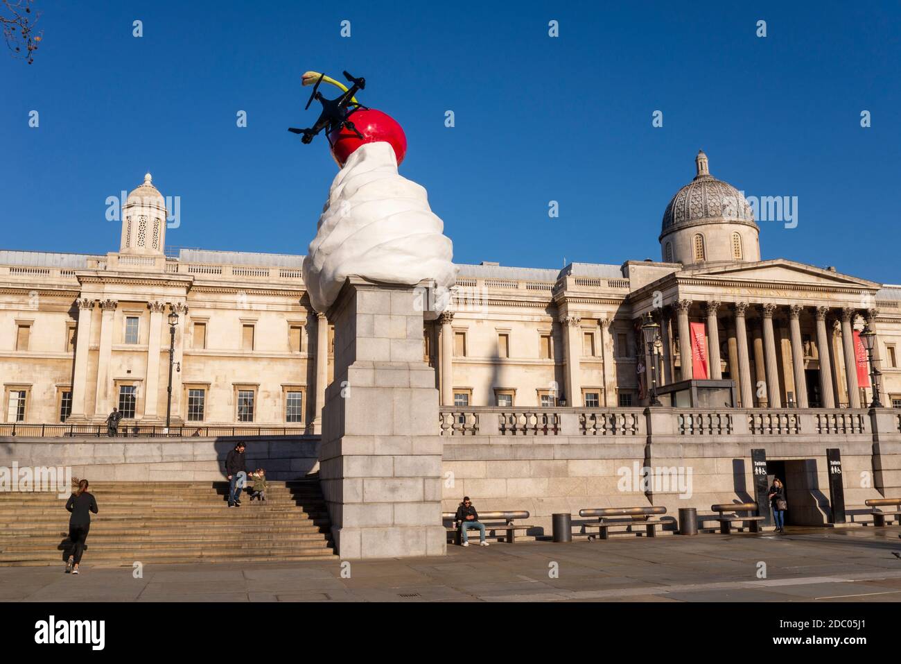 The End. Dollop of whipped cream with assortment of toppings: a cherry, a fly, and a drone. Fourth plinth art outside National Gallery. Lockdown quiet Stock Photo