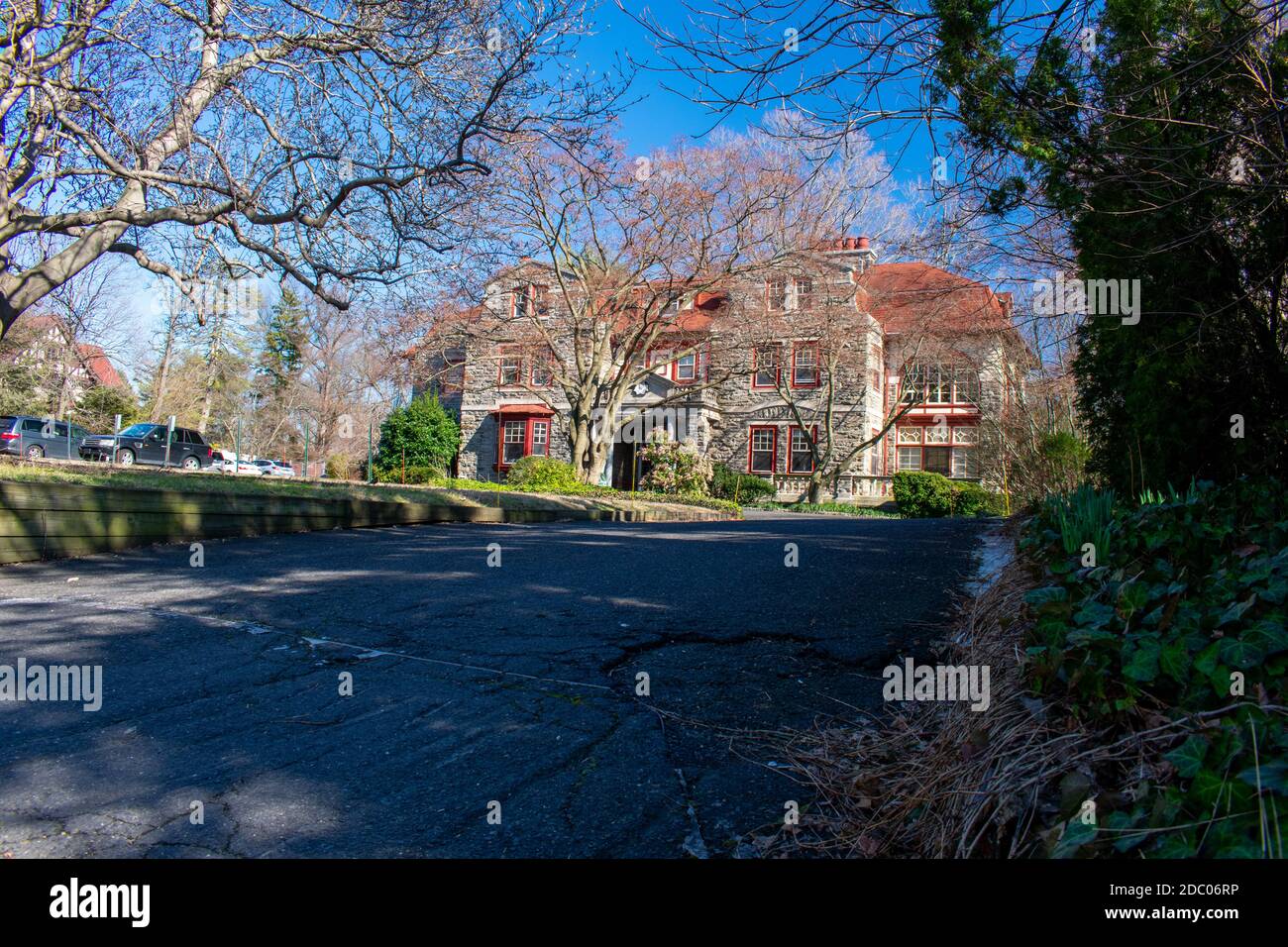 A Large Estate Like Property With a Large Driveway on a Clear Blue Sky Stock Photo