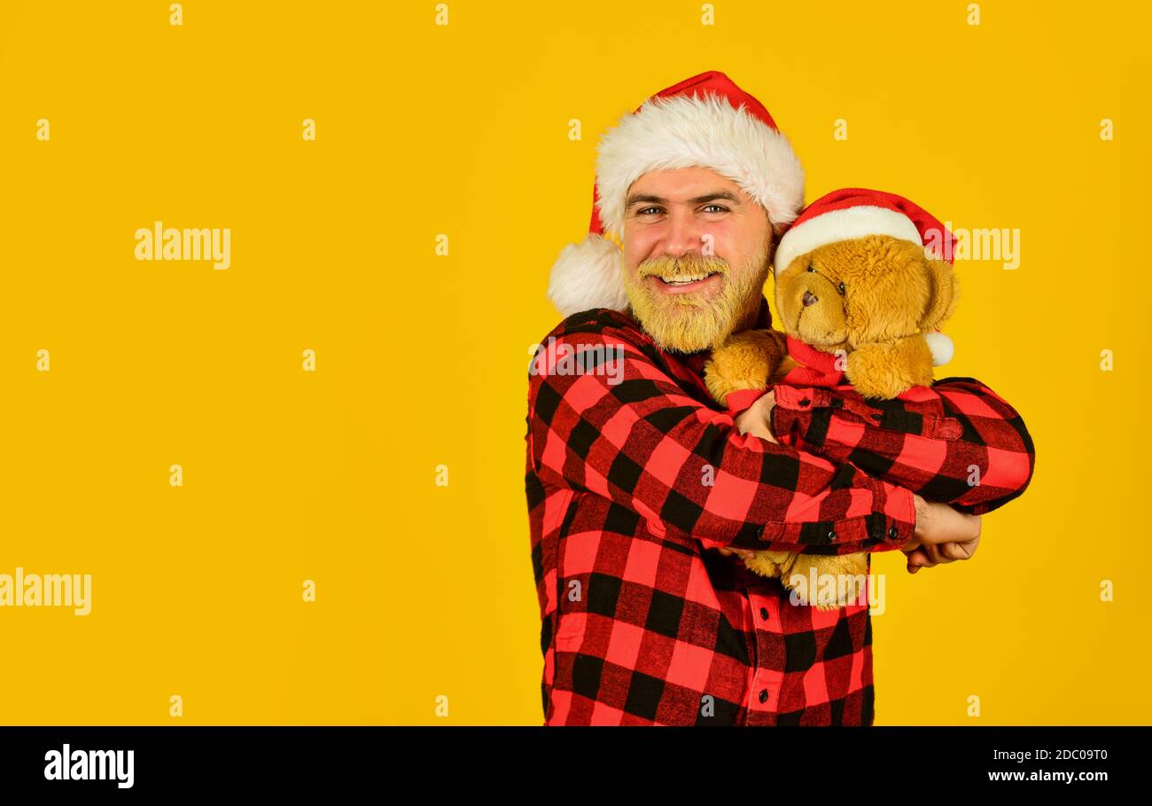 Santa Claus. Mature man with long beard. Christmas spirit. Christmas time for mercy. Charity project. Bearded man celebrate christmas. Kind hipster with teddy bear. Charity and kindness. Lovely hug. Stock Photo