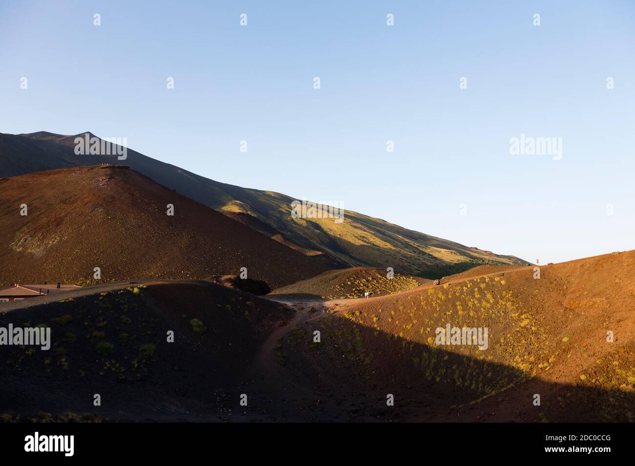Sicily, Italy. Tourists make the steep climb up the Silvestri Superiori crater near the summit of Mt Etna. Stock Photo