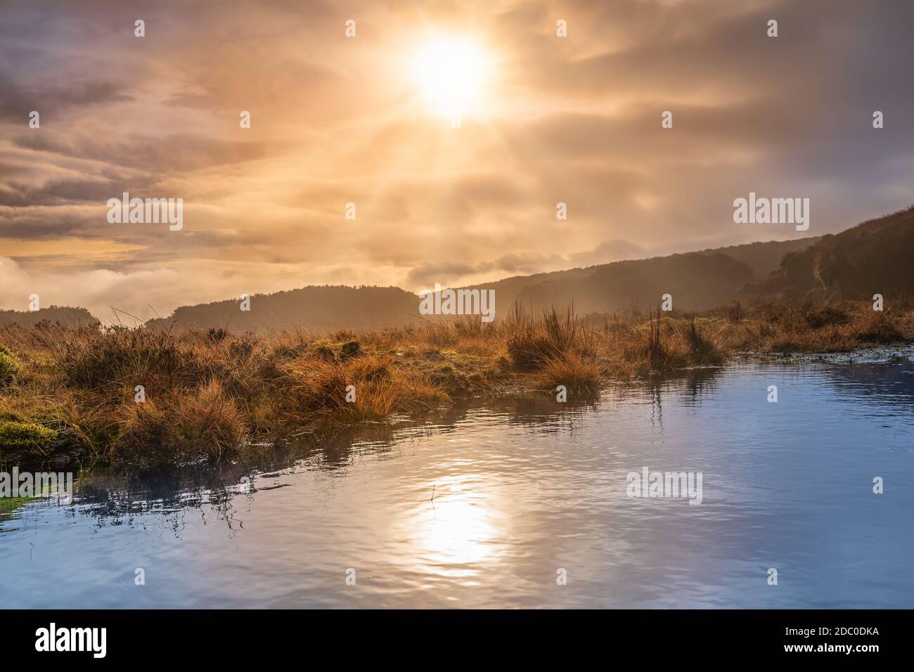 Fog, mist and dramatic sky over a swamp or bog with sun reflecting in a lake. Dramatic landscape of Wicklow mountains, Ireland Stock Photo