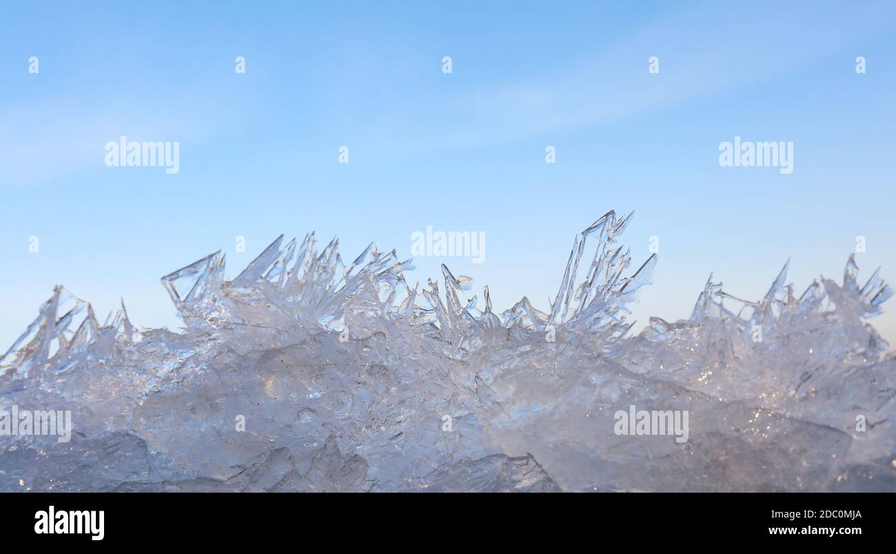 Close up lacy ice crystals pattern over clear blue sky background, low angle view Stock Photo