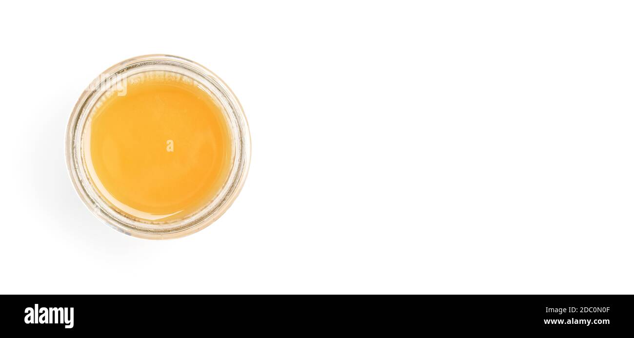 Glass jar with amber coloured honey, view from above, isolated on white background, space for text right side. Stock Photo