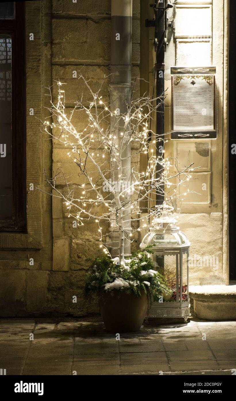 LVIV, UKRAINE - DECEMBER 24, 2018: Restaurant decorated with New Year's decor. Little tree with light garlands on the background of restaurant Stock Photo