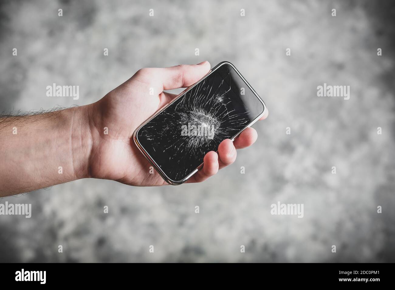 Smart cell phone with a broken screen in hand Stock Photo