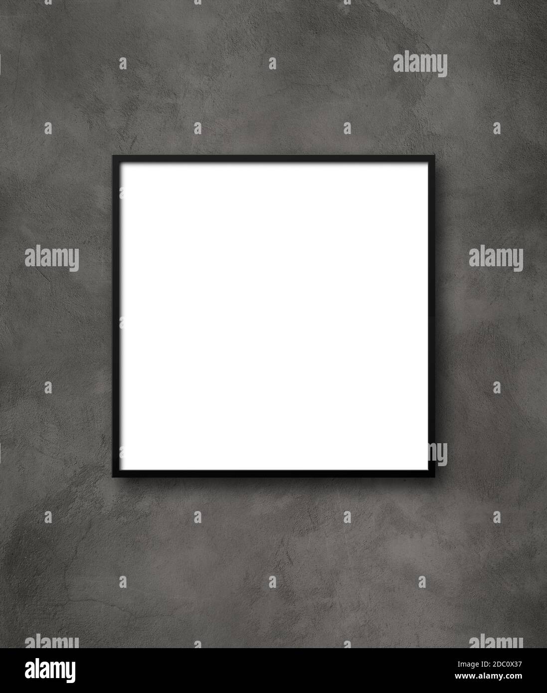 Black square picture frame hanging on a dark concrete wall. Blank ...