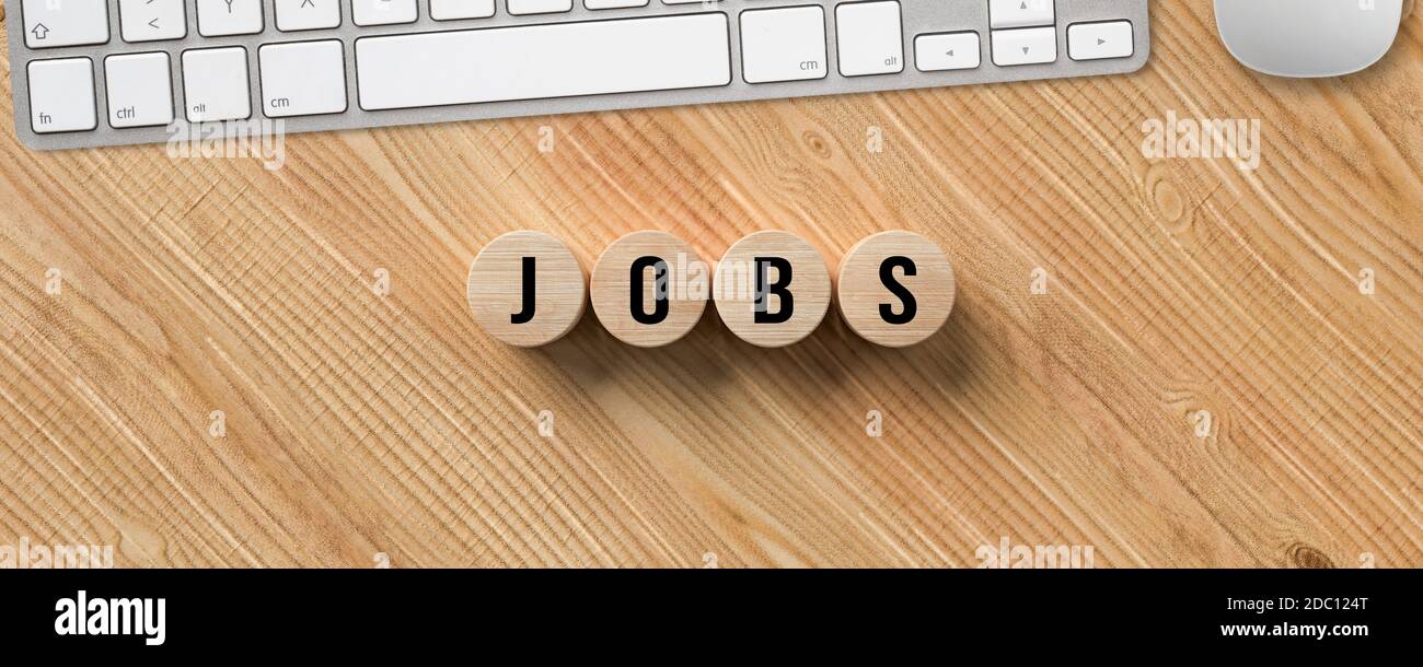 computer keyboard and cylinders with message JOBS on wooden background Stock Photo