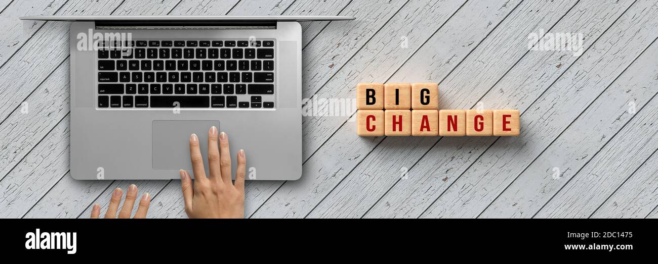 hand is typing on a computer keyboard and cubes with message BIG CHANGE on wooden background Stock Photo