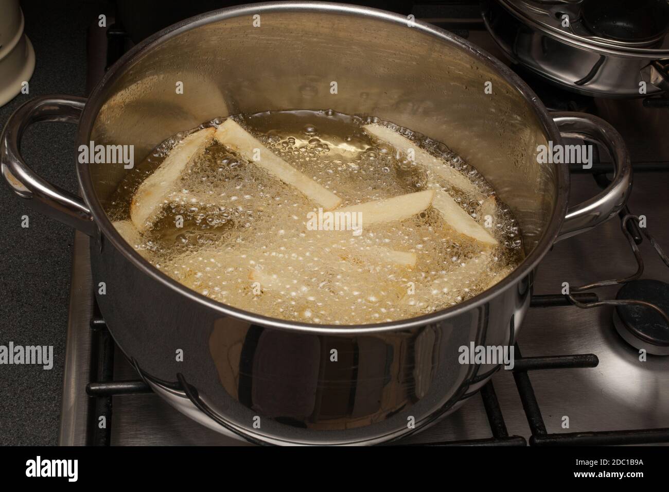 Homemade potato chips frying in a pan of hot oil Stock Photo Alamy