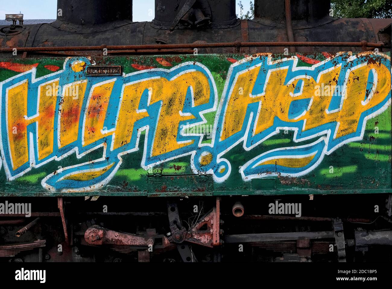 ‘Hilfe’ and ‘Help’ bilingual pleas in German and English colourful spray can graffiti on a rusting steam locomotive awaiting restoration (in 2008) at the former north east terminus in Heidenreichstein, Gmünd, Lower Austria, of the Waldviertelbahn or Waldviertler Schmalspurbahn.  The railway is a former industrial 760 mm narrow gauge network today preserved and run by the provincial government and enthusiasts as a heritage attraction. Stock Photo