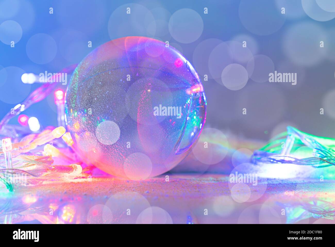 Snowglobe or glass ball covered by snow with garland, Christmas decoration, layout, space for text, postcard. Stock Photo