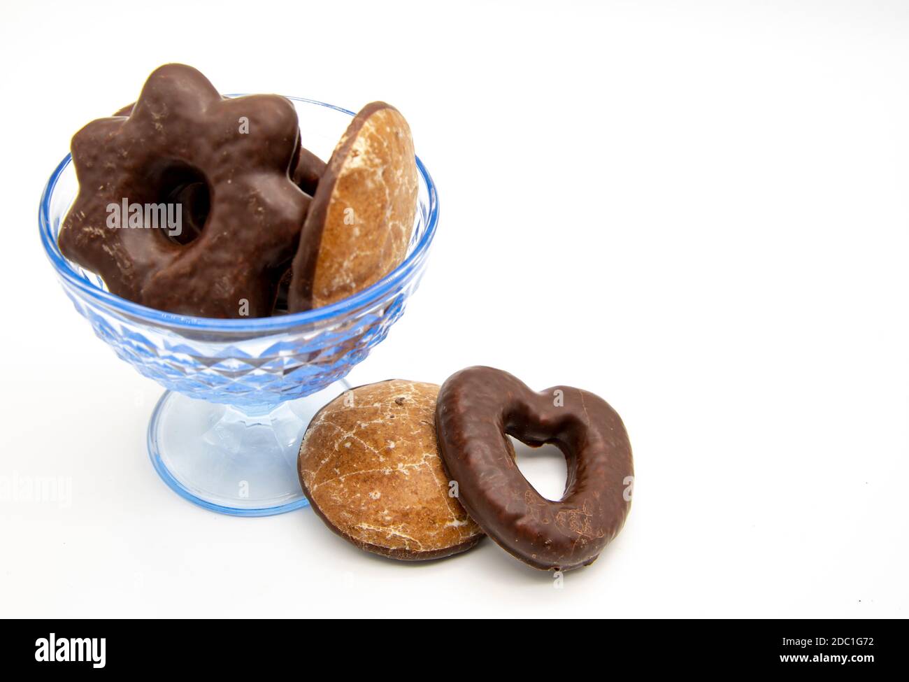 On a white background, a blue glass vase with gingerbread cakes of different sizes and shapes. Stock Photo