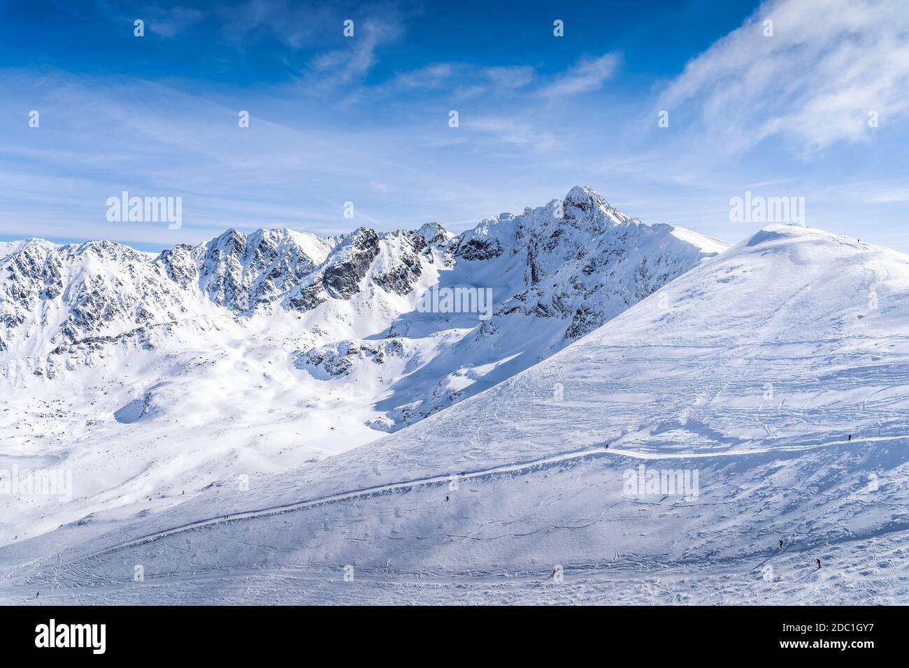 People skiing and snowboarding from Kasprowy Wierch, winter holidays. Amazing mountain range with snow capped mountain peaks in Tatra Mountains Poland Stock Photo