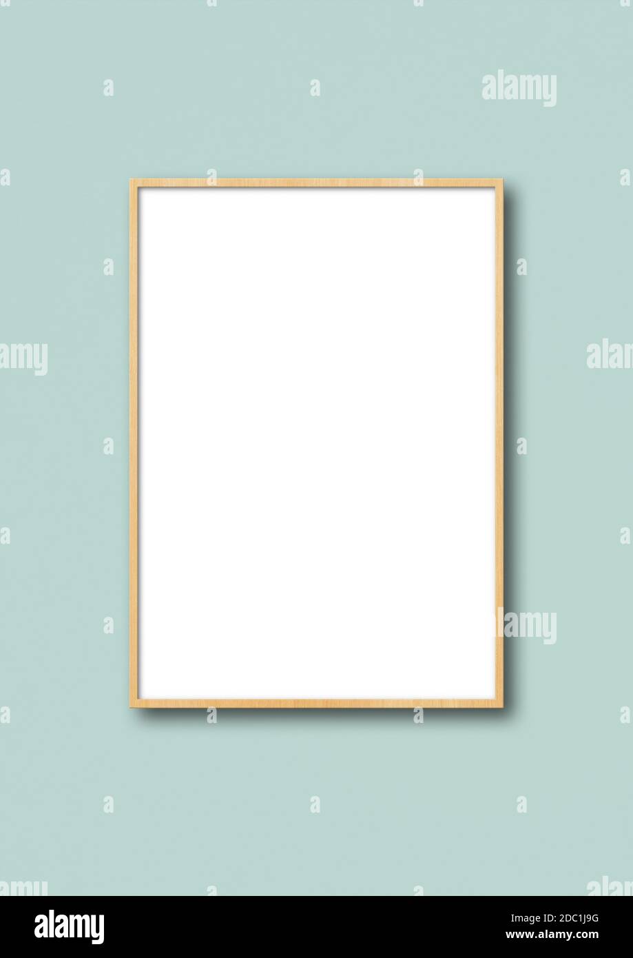 Wooden picture frame hanging on a light blue wall. Blank mockup ...