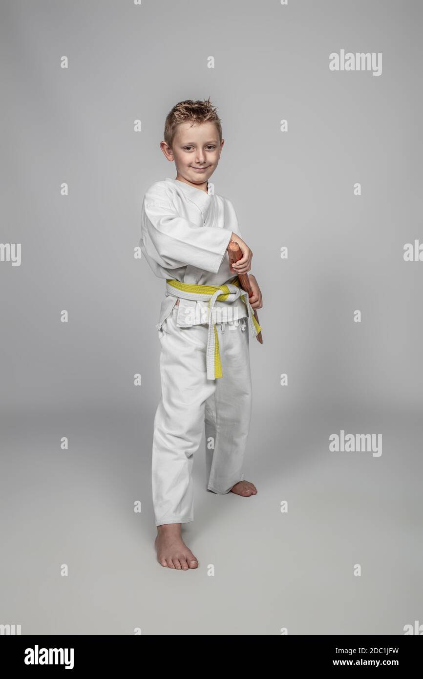 smiling child practicing martial arts with a wooden bokken. Stock Photo