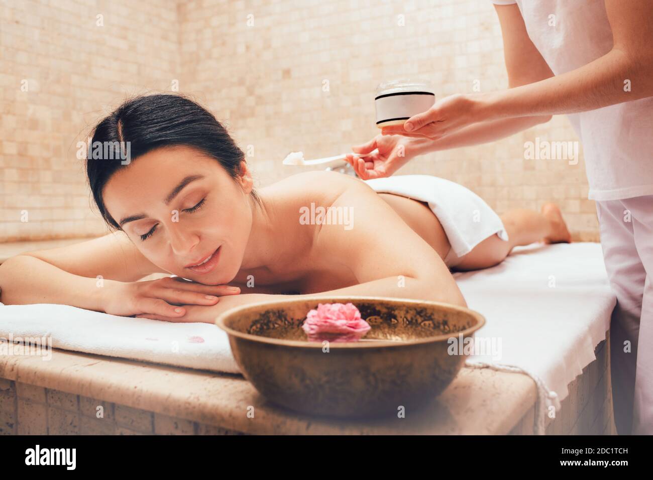 Exfoliate older skin with a body scrub. Time for pampering body and skin at spa. Brunette getting peel procedure after body massage. Stock Photo