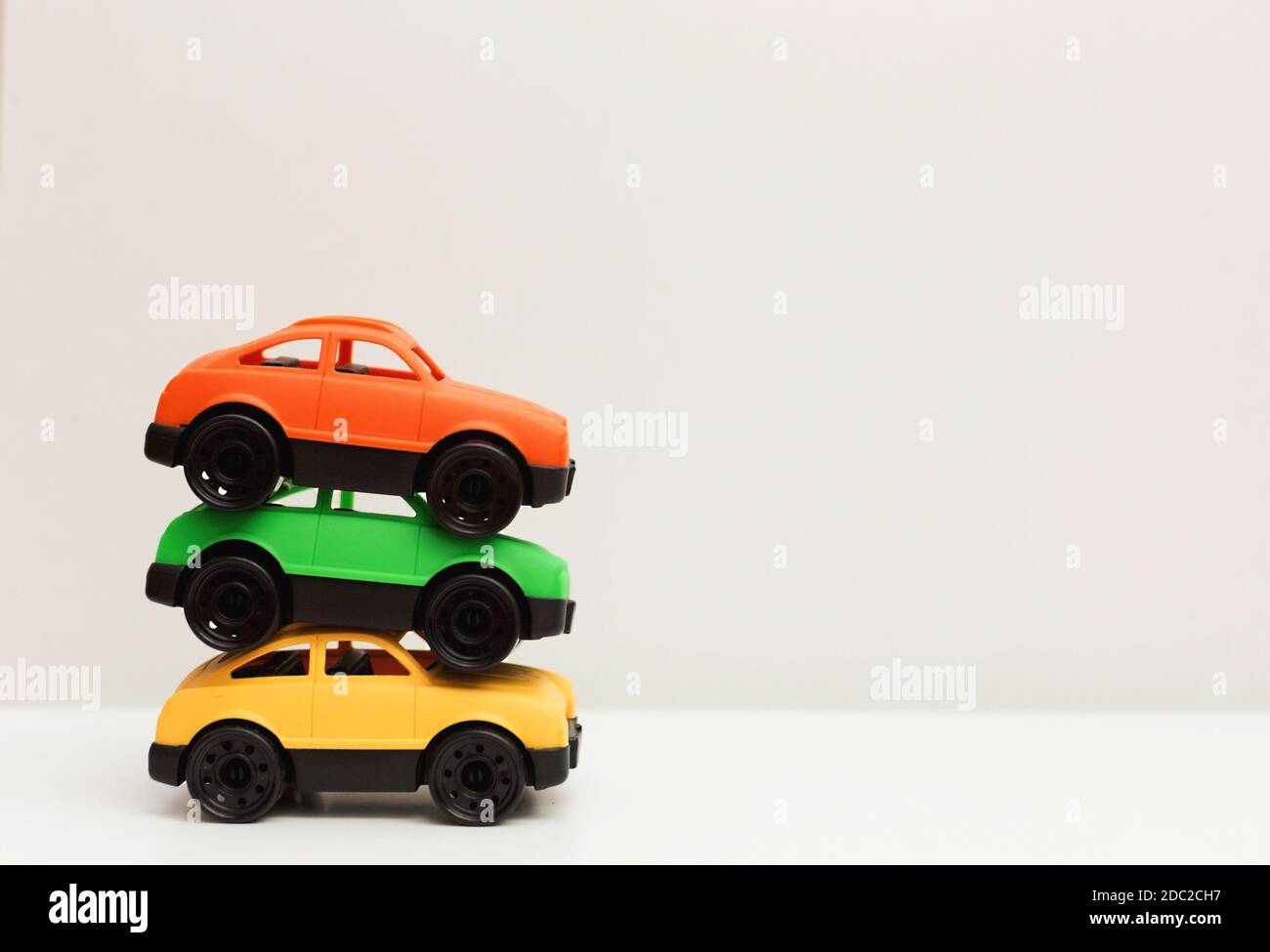 Three colorful toy cars made from recyclable non toxic plastic at white
