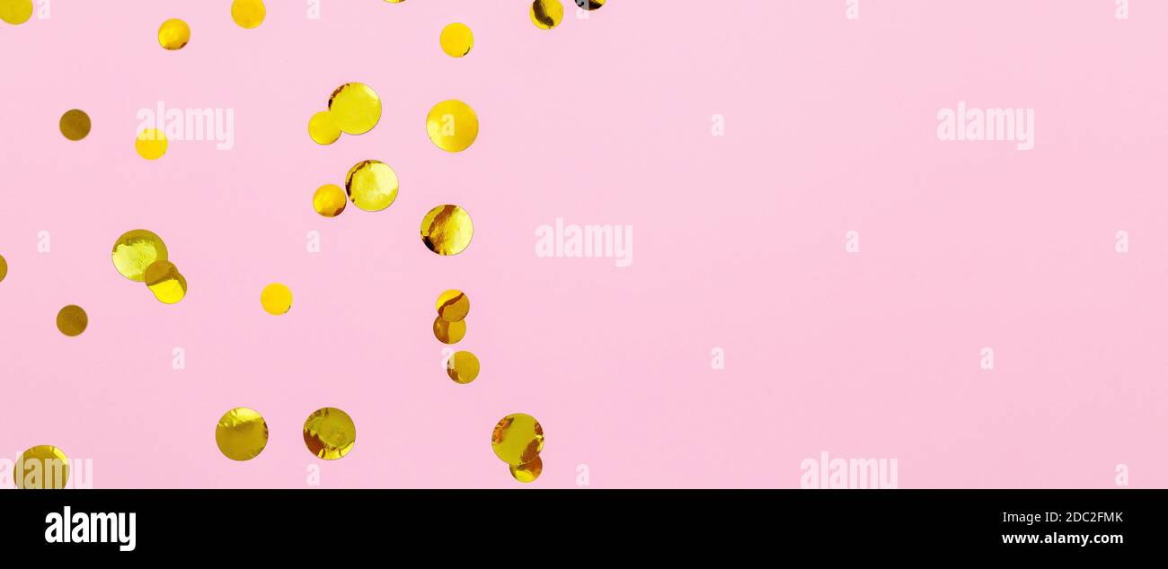 Gold confetti sparkles frame on pink background. Flat lay, top view festive backdrop with copy space. Celebration concept. Long web banner Stock Photo