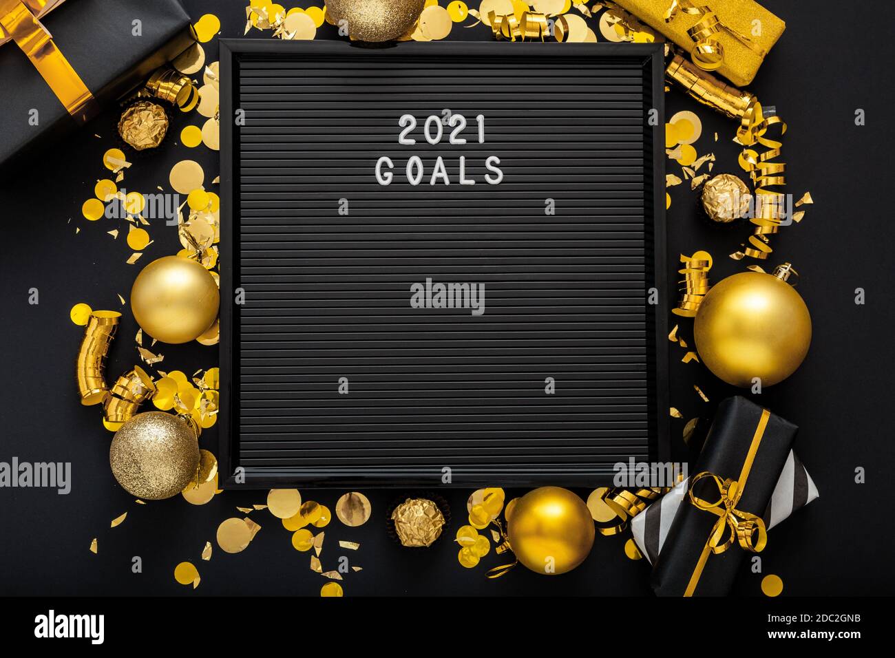 2021 Goals text on black Letter Board with gold Christmas festive decor, confetti balls. New year 2021 goals, resolution, check list with motivation Stock Photo