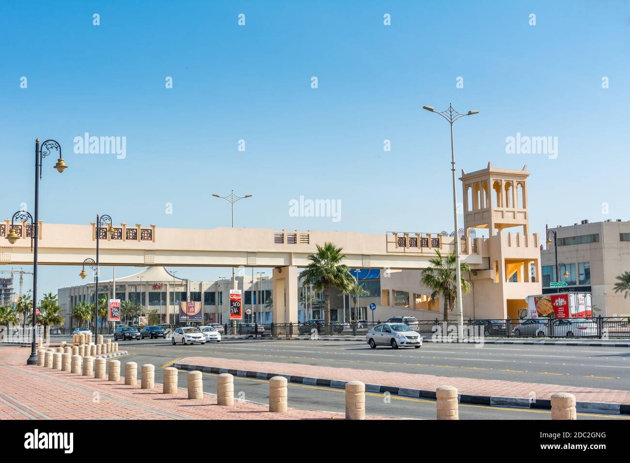 A footbridge with background of modern shopping mall near the corniche