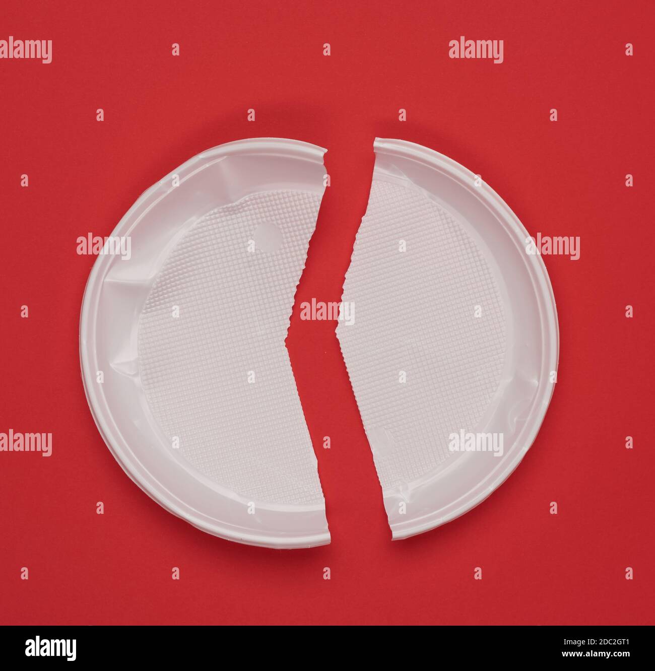 disposable white plastic plate on a red background, top view Stock Photo