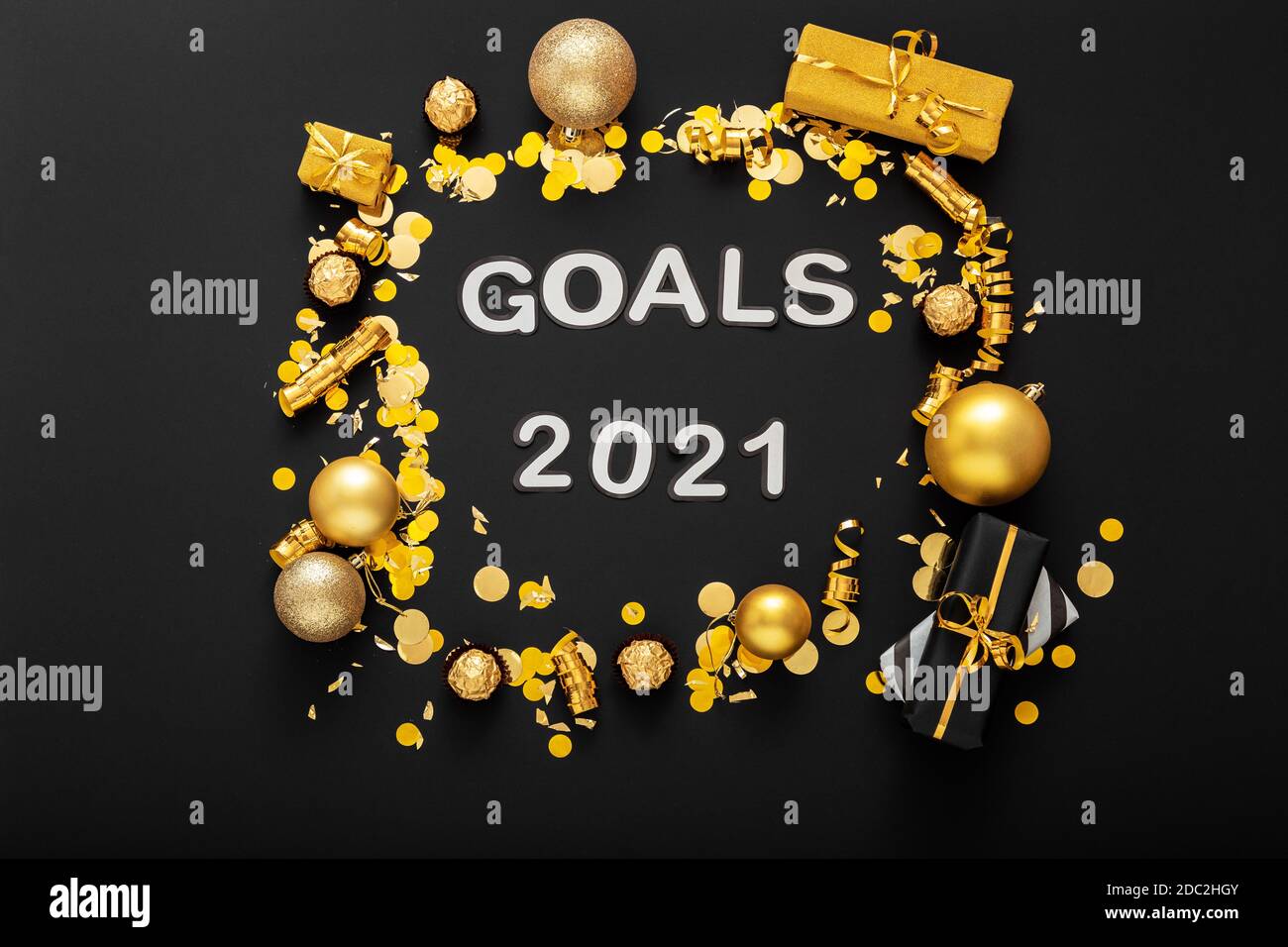 2021 Goals text on black background in frame made of gold Christmas festive decor, confetti balls. New year 2021 goals, resolution check list with Stock Photo