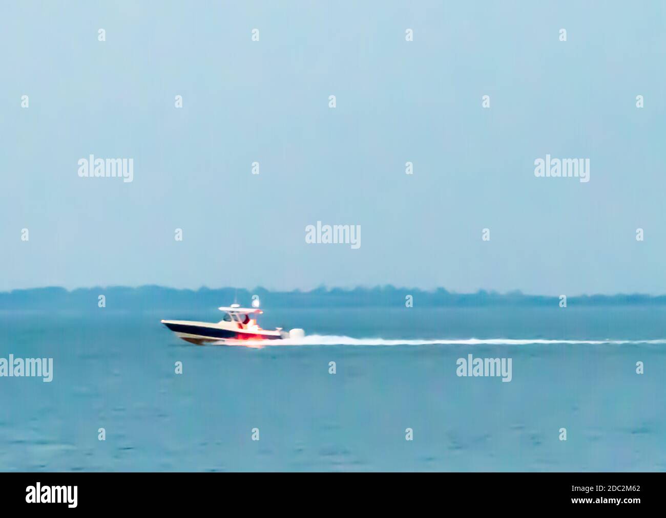 boat running fast just before night fall, East Hampton, NY Stock Photo