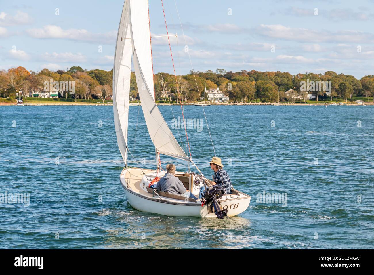 A couple sailing a small sail boat near Dering Harbor, NY Stock Photo
