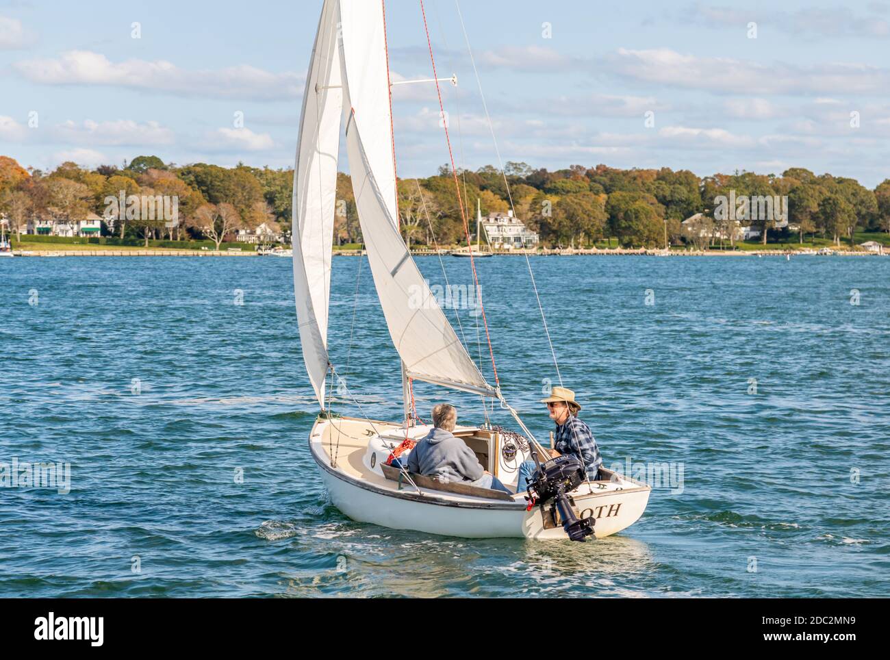 A couple sailing a small sail boat near Dering Harbor, NY Stock Photo