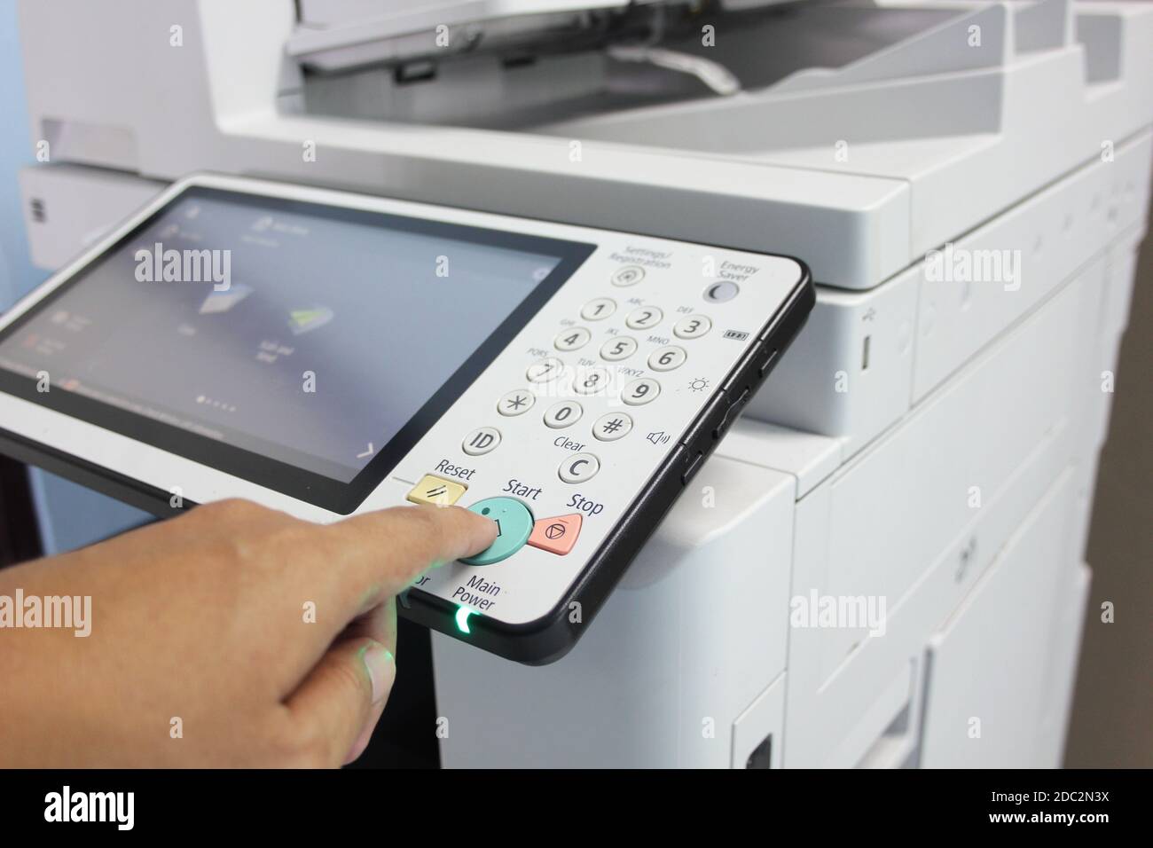 Bussiness man Hand press button on panel of printer, printer scanner laser office copy machine supplies start concept. Stock Photo