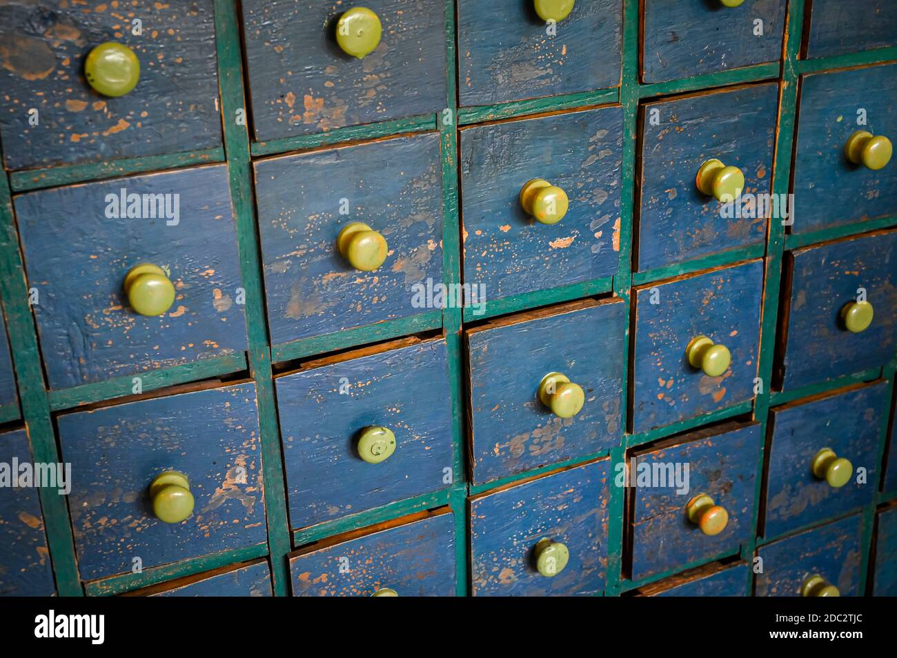 Rows of small wooden drawers with a distressed paint finish. Stock Photo