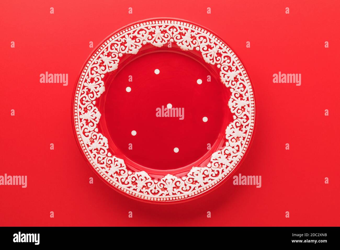 Empty red plate with New Years pattern on a red background, top view Stock Photo