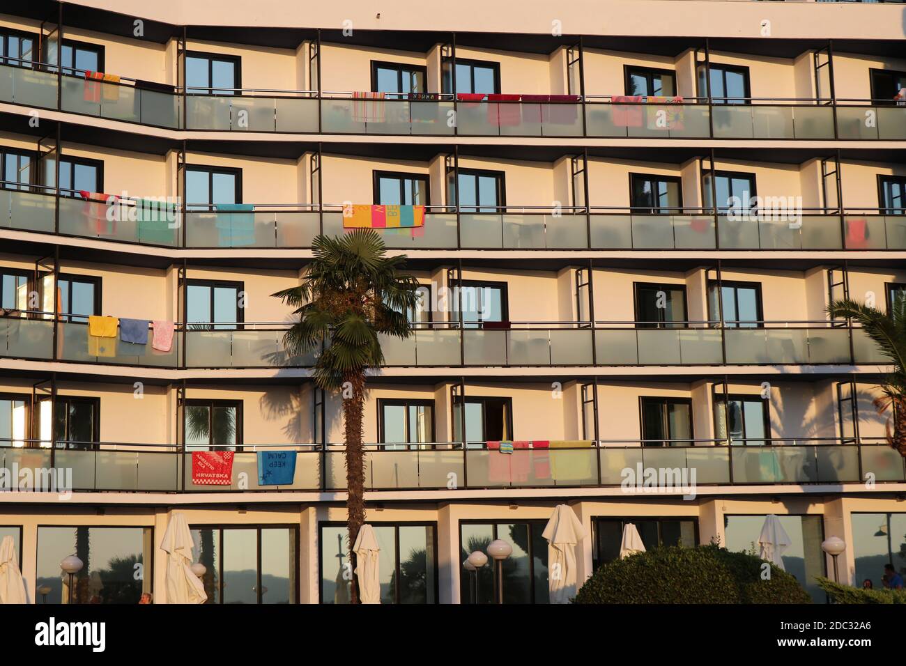 View of front of a buliding wall with multiple windows and balconies Stock Photo