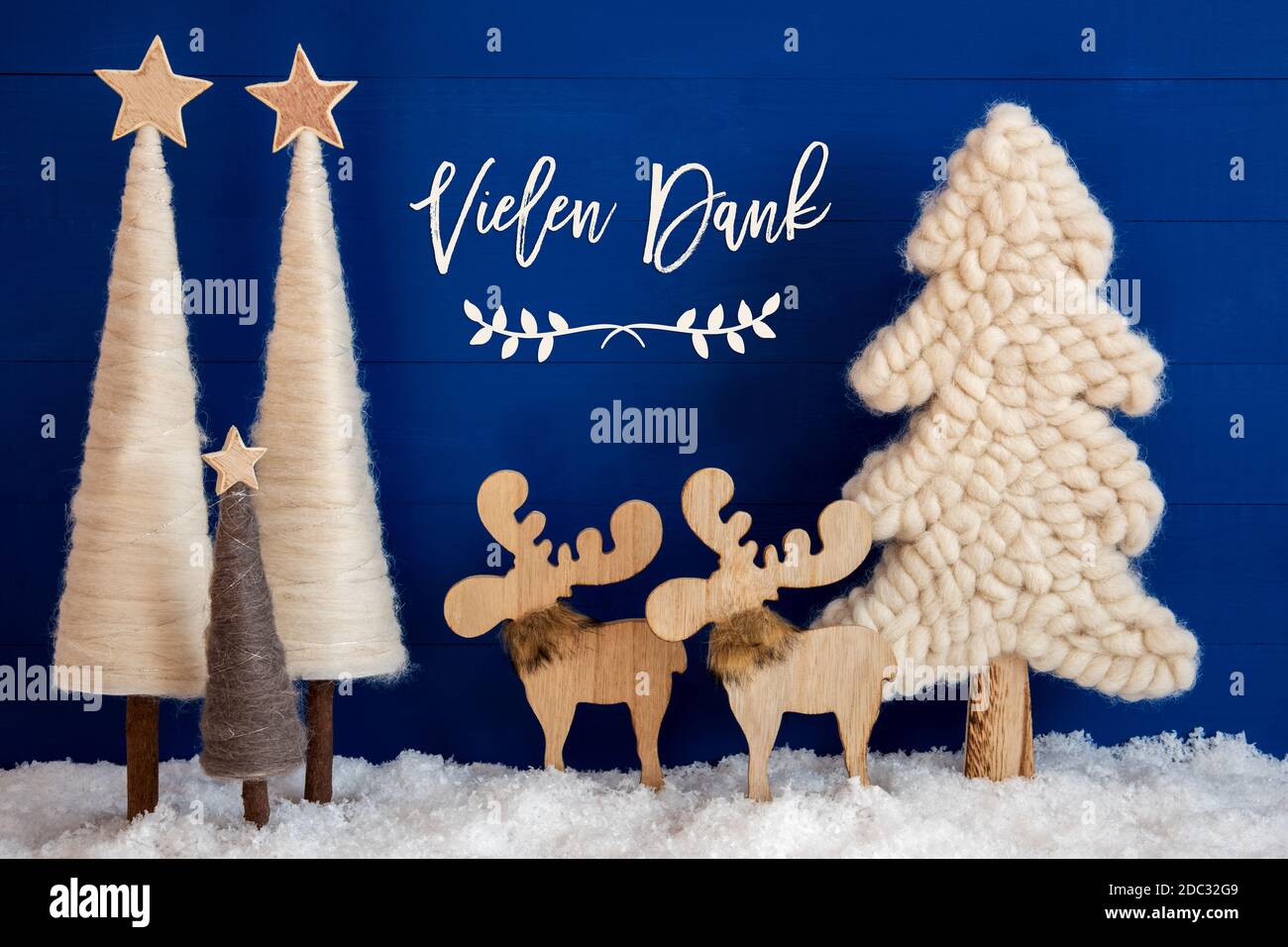 German Calligraphy Vielen Dank Means Thank You On Blue Background With Snow. Decoration And Ornament Like Christmas Trees And A Moose Couple. Stock Photo