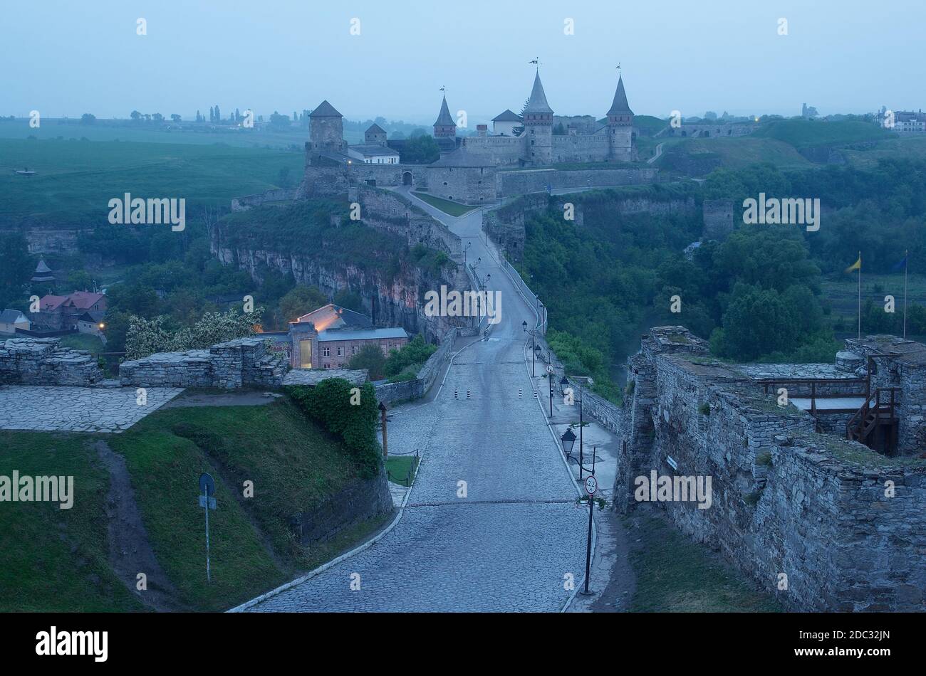 Road leading to the medieval castle. Fortification historical landmark. Cityscape at dusk. Kamenetz-Podolsk, Ukraine, Europe Stock Photo