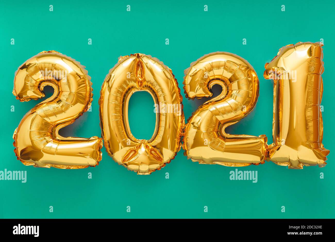 2021 air balloon gold text on green background. Happy New year eve invitation with Christmas gold foil balloons 2021. Stock Photo