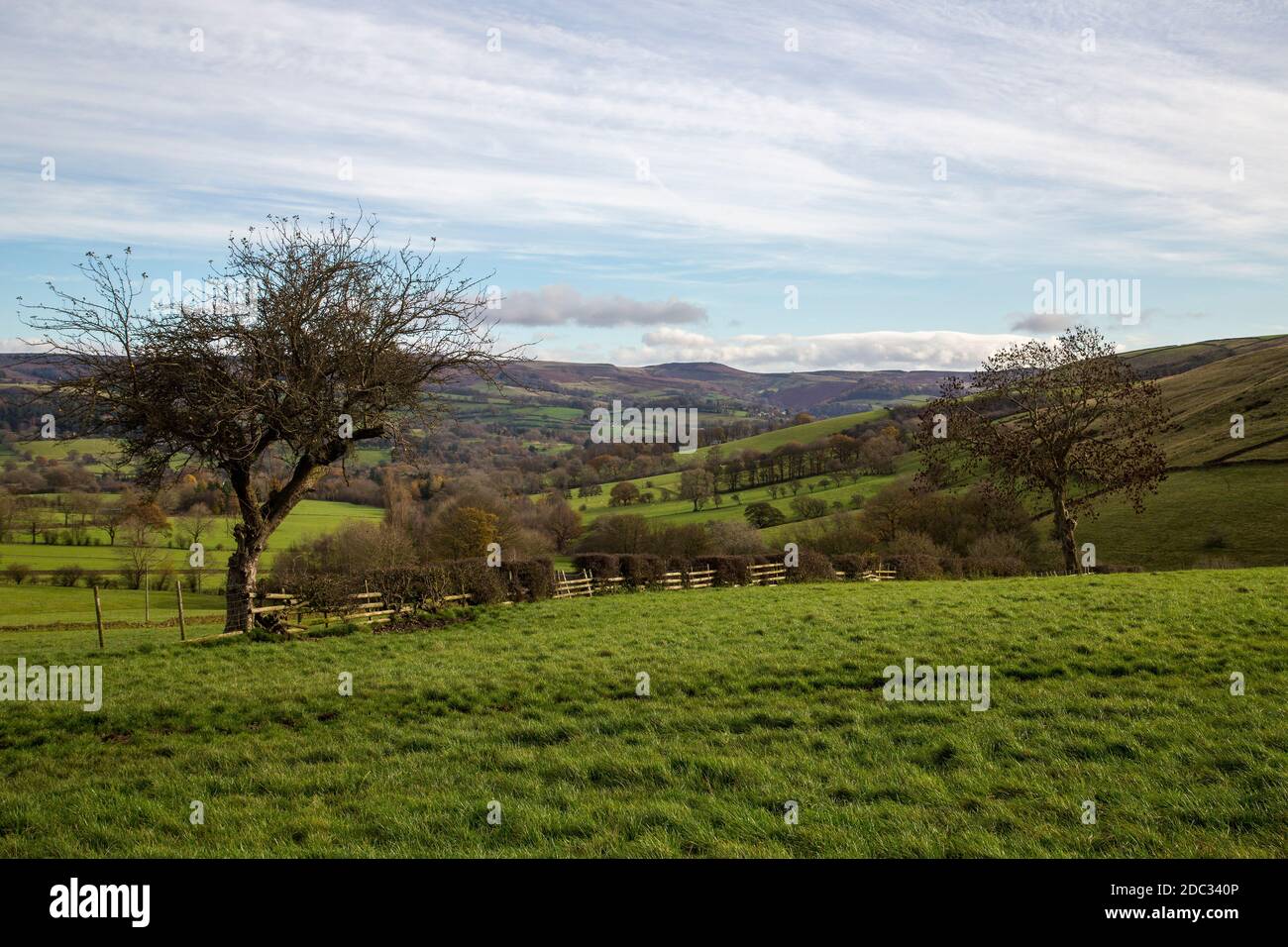 A view across a valley over fields in the Derbyshire Dales on a changeable autumnal day Stock Photo