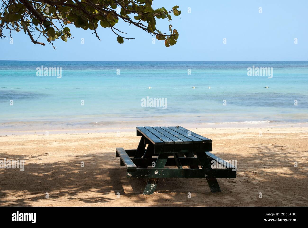 The picnic table in a tree shadow on Ocho Rios resort town beach ...