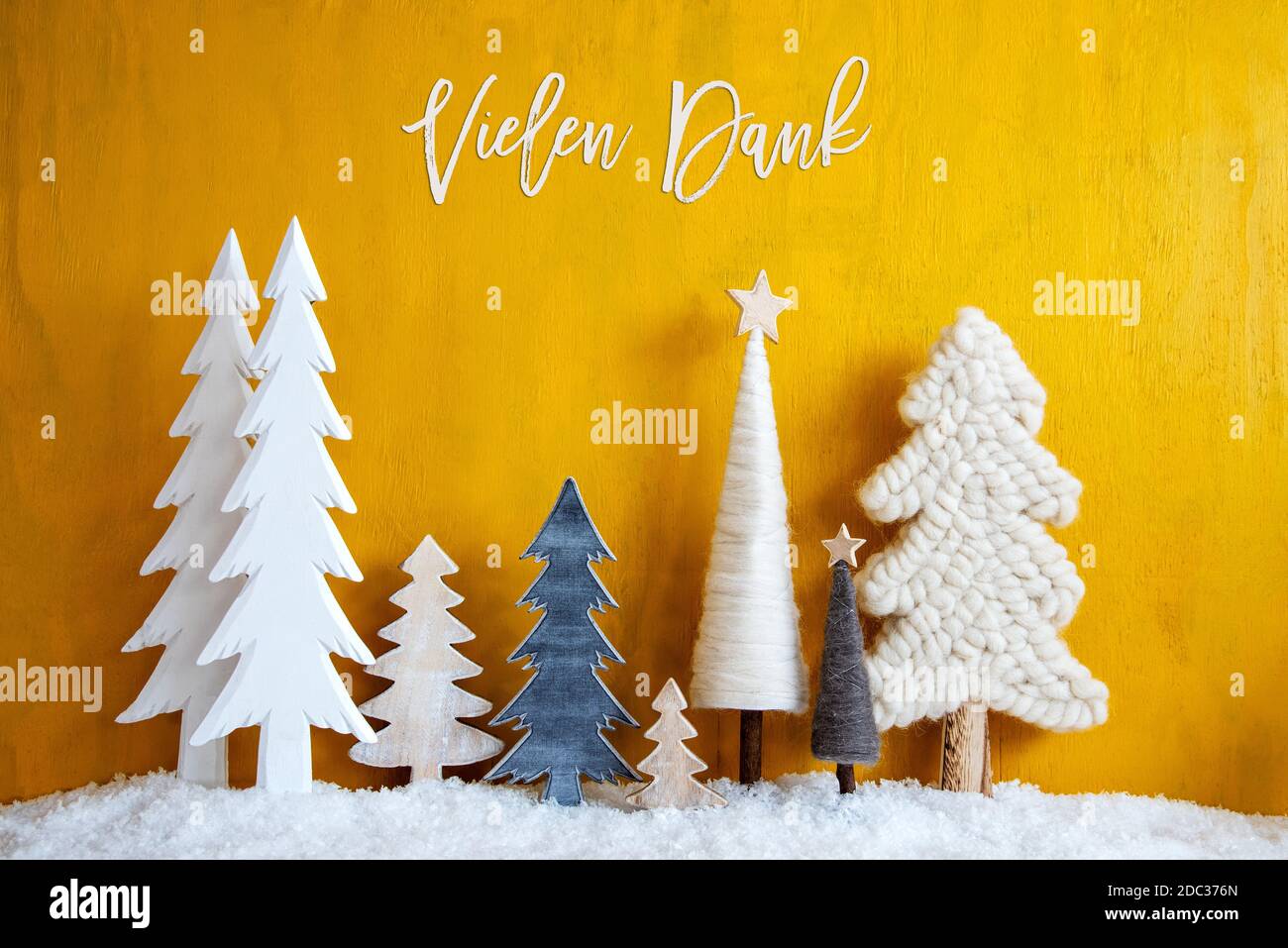 Christmas Trees With German Calligraphy Vielen Dank Means Thank You. Yellow Wooden Rustic Background With Snow. Christmas Decoration With Stars. Stock Photo