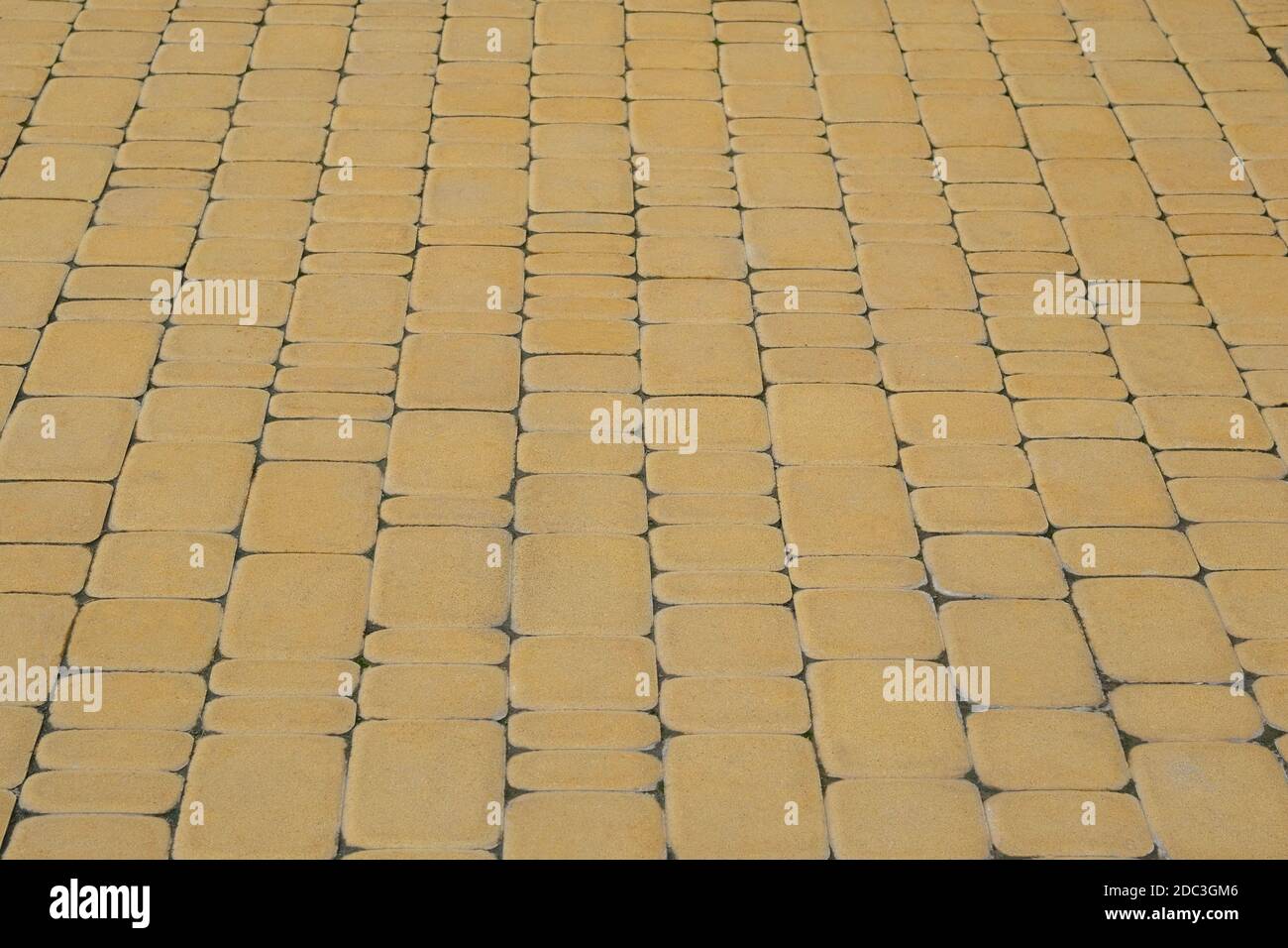 Yellow Paving slab, background. Pedestrian zone in the park in daylight. Walkway. Stock Photo