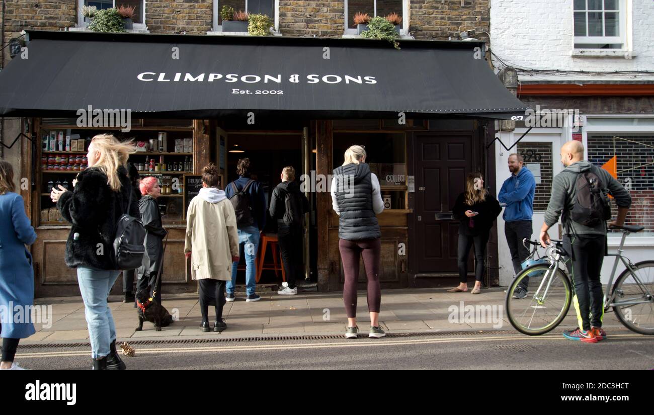 Hackney,London November 2020 during the Covid-19 (Coronavirus) pandemic. Lockdown 2. Broadway Market. Climpsons and sons coffee shop - people wait for Stock Photo