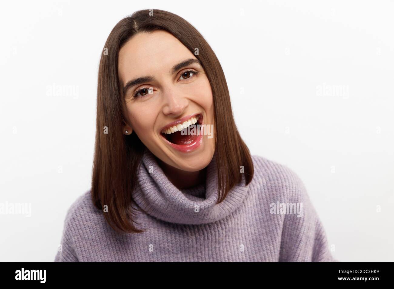 Studio shot of smiling glad woman has appealing appearance, smiles broadly, poses against white background expresses positive emotions likes  Stock Photo