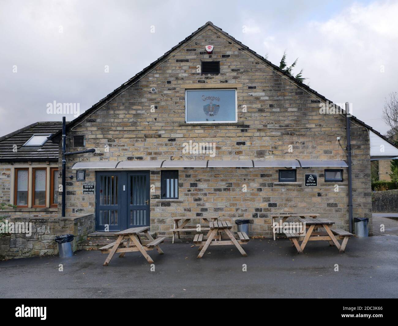Roadside stone built fish and chip shop front and side tables blue doors first floor stained glass window with compo write roof windows and canopy Stock Photo