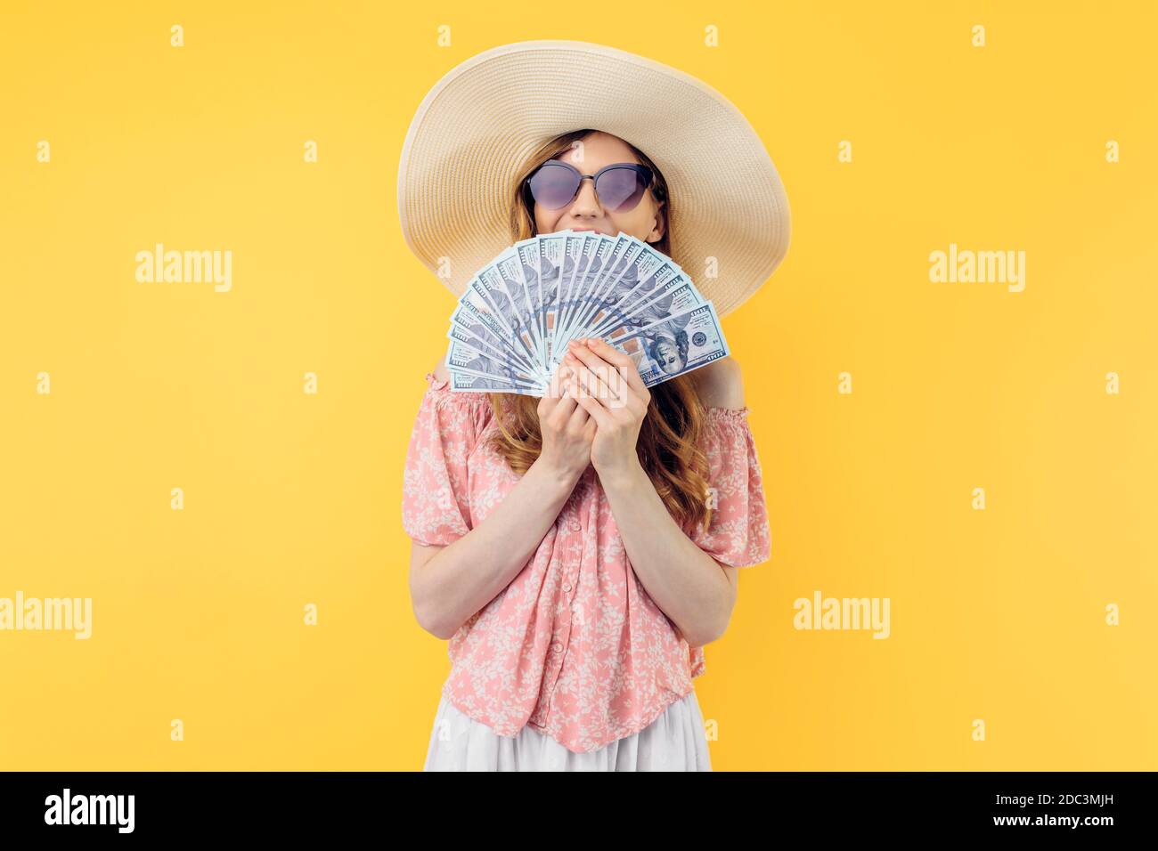 straw hat with yellow suitcase isolated 