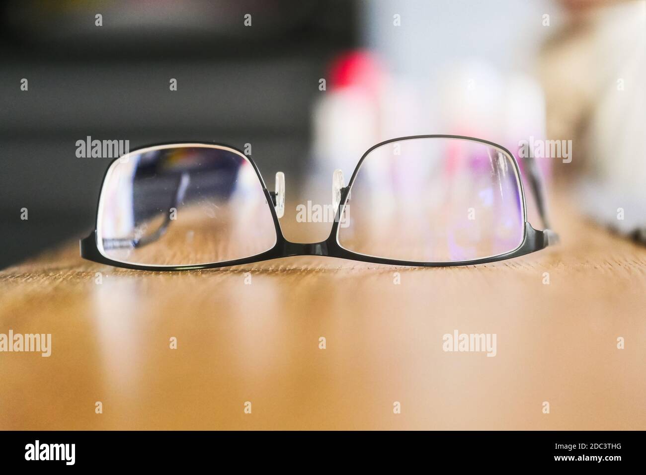 Eyeglasses upside down on wooden surface. Close up. Selective focus. Stock Photo