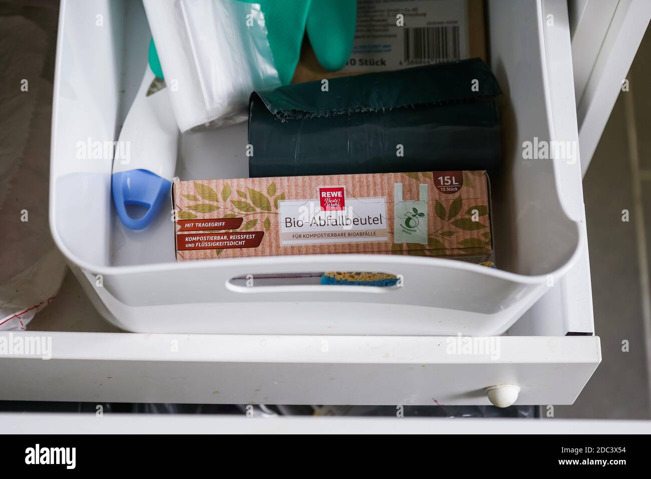 Recyclable sustainable garbage container packaging inside bin with household objects. High angle view. Stock Photo