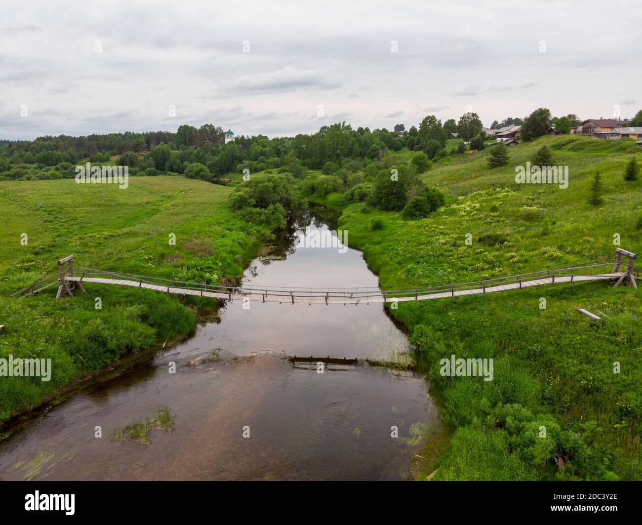 Suspension bridge over the Puya river. Russia, Arkhangelsk region, Velsky district, Andrichevo village Stock Photo