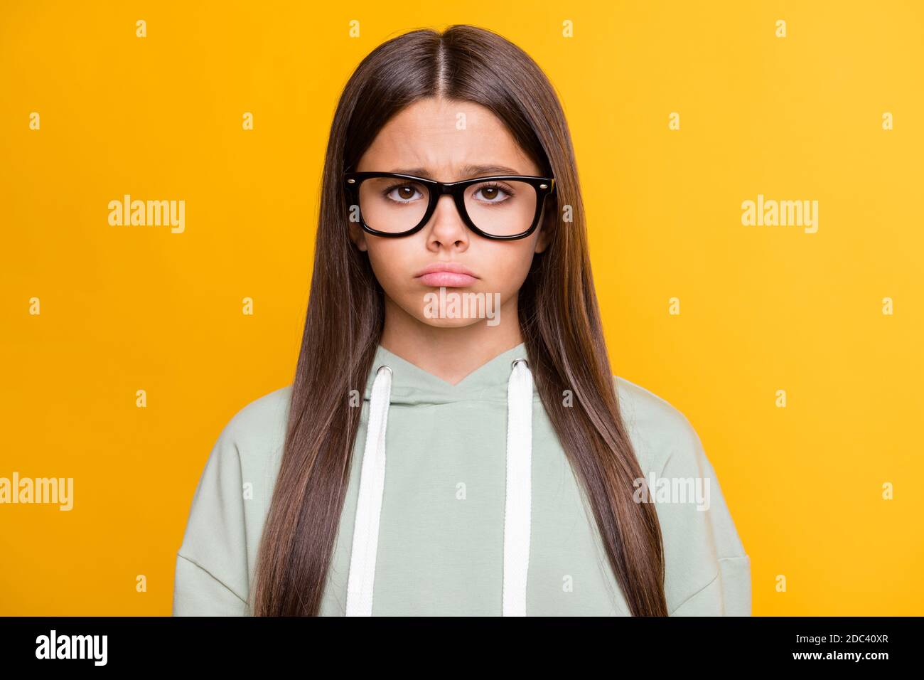 Photo of sad stressed funny school girl wear casual grey outfit glasses isolated yellow color background Stock Photo